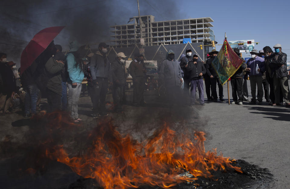 Manifestantes con tapabocas por el nuevo coronavirus queman un neumático durante una protesta contra el aplazamiento de las próximas elecciones presidenciales en El Alto, Bolivia, el lunes 3 de agosto de 2020. La máxima autoridad electoral de Bolivia retrasó las elecciones presidenciales del 6 de septiembre al 18 de octubre. (AP Foto/Juan Karita)