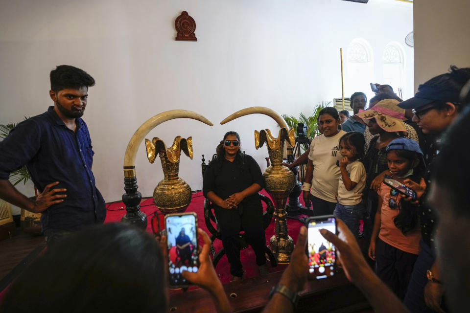 Protesters look around and pose for photographs at the president's official residence a day after it was stormed in Colombo, Sri Lanka, Sunday, July 10, 2022. Sri Lanka’s president and prime minister agreed to resign Saturday after the country’s most chaotic day in months of political turmoil, with protesters storming both officials’ homes and setting fire to one of the buildings in a rage over the nation's severe economic crisis. (AP Photo/Eranga Jayawardena)