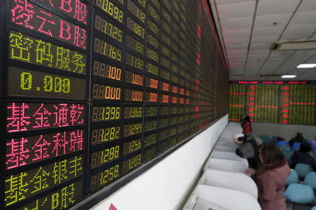 Investors look at computer screens showing stock information on the first trading day after the week-long Lunar New Year holiday at a brokerage house in Shanghai, China, February 15, 2016. REUTERS/Aly Song