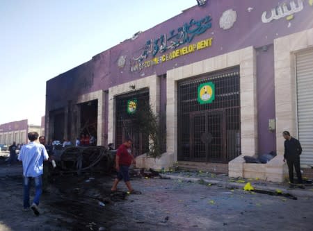 People gather at the site where a car bomb exploded in Benghazi