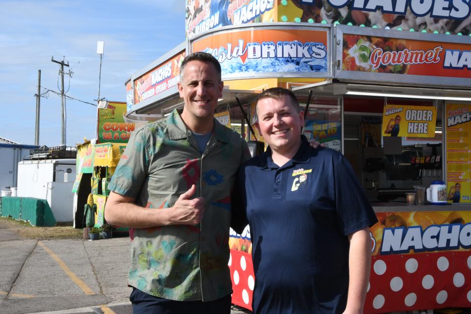 "Carnival Eats" host Noah Cappe stands with Rosie's Nachos vendor owner Casey White during filming at the South Florida Fair.