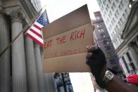 A demonstrator with Occupy Chicago holds up a sign outside the Federal Reserve Bank building October 5, 2011 in Chicago, Illinois. The protest is one of many around the country being held in solidarity with the Occupy Wall Street protests currently taking place in New York City. Among the things that demonstrators are protesting is what they believe is greed and corruption among banking and business leaders. (Photo by Scott Olson/Getty Images)