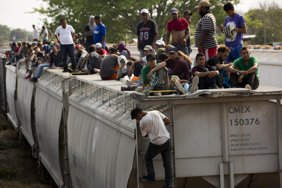 Central American migrants wait on the top of a parked train during their journey toward the US-Mexico border in Ixtepec, Oaxaca state, Mexico, Tuesday, April 23, 2019. The once large caravan of about 3,000 people was essentially broken up by an immigration raid on Monday, as migrants fled into the hills, took refuge at shelters and churches or hopped passing freight trains. (AP Photo/Moises Castillo)
