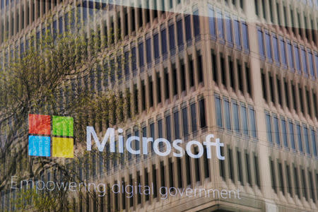 FILE PHOTO: An promotional video plays behind a window reflecting a nearby building at the Microsoft office in Cambridge, Massachusetts, U.S. on May 15, 2017. REUTERS/Brian Snyder/File Photo