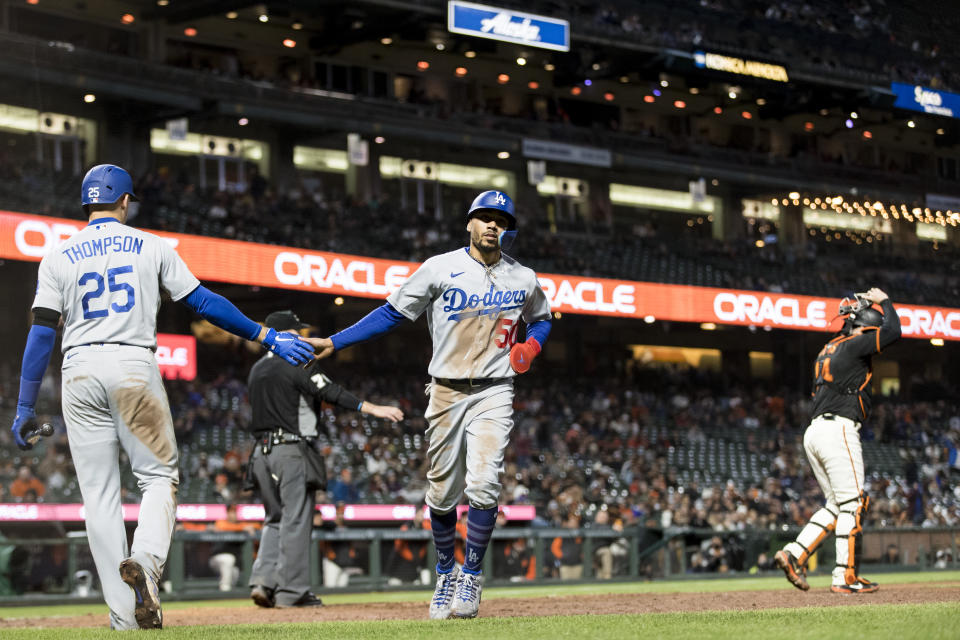 Los Angeles Dodgers' Mookie Betts, right, is congratulated by Trayce Thompson (25) after he scored against the San Francisco Giants during the tenth inning of a baseball game in San Francisco, Sunday Sept. 18, 2022. The Dodgers won 4-3. (AP Photo/John Hefti)