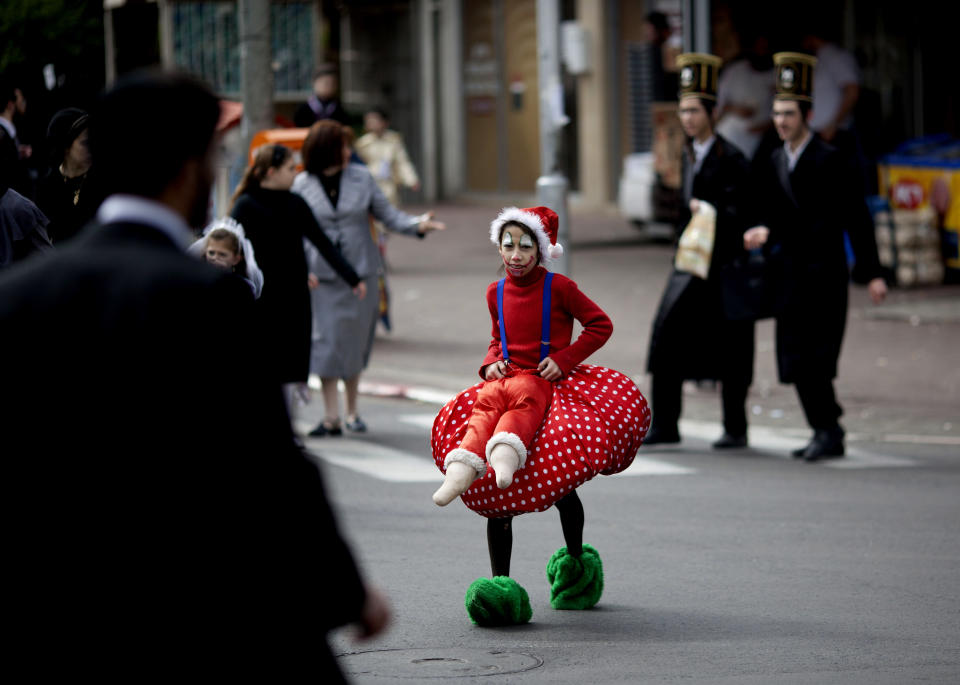 An Ultra Orthodox Jewish girl dressed wearing a costume crosses the street during the Purim festival in the ultra-Orthodox town of Bnei Brak, Israel, Sunday, Feb. 24, 2013.  (AP Photo/Ariel Schalit)