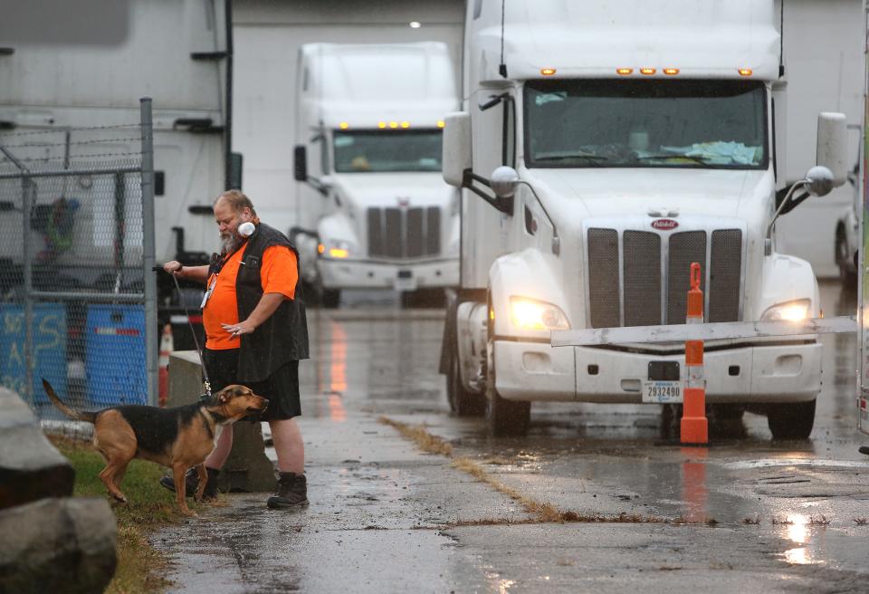 Former Celadon truck driver Jack Jobes of Pensacola, Florida walks his dog Bella Monday at Celadon on East 33rd Street. Jobes rented a U-Haul van for transportation after turning in his semi truck to the company.