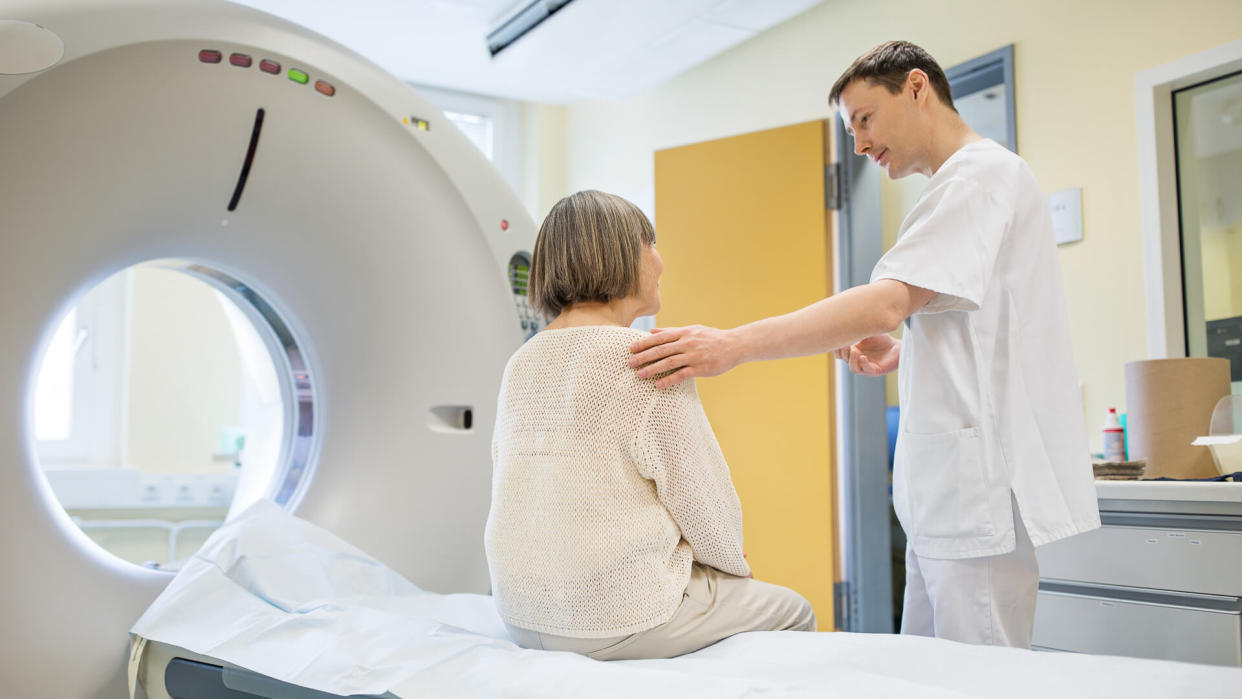 Surgeon consoling female patient in examination room.