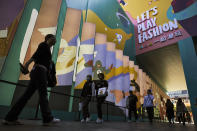 Shoppers wearing face masks to help curb the spread of the coronavirus walks through the capital city's popular shopping mall in Beijing, Monday, Oct. 19, 2020. China’s shaky economic recovery from the coronavirus pandemic is gaining strength as consumers return to shopping malls and auto dealerships while the United States and Europe endure painful contractions. (AP Photo/Andy Wong)