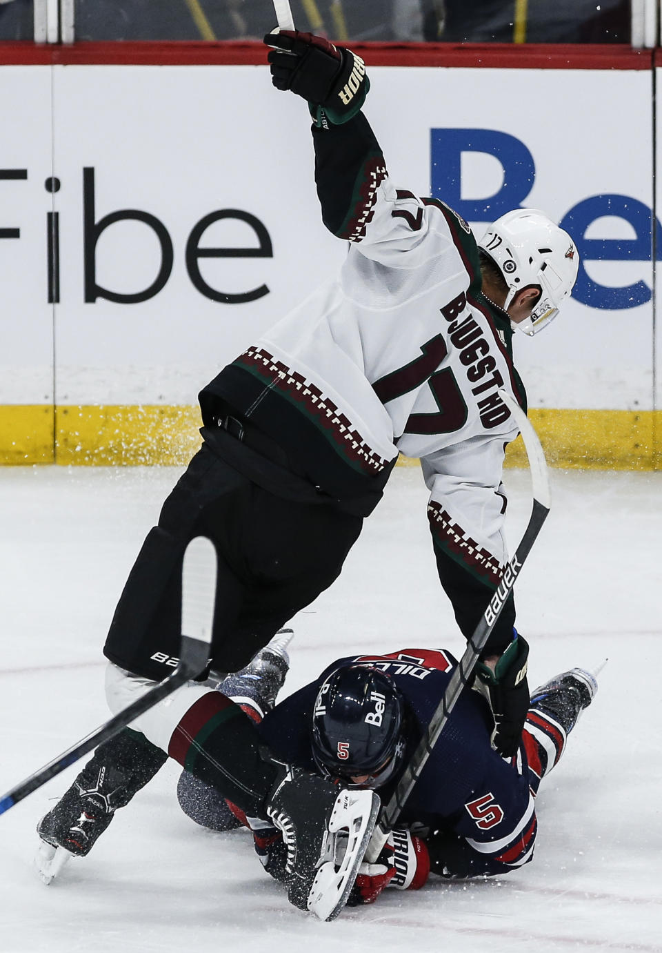 Winnipeg Jets' Brenden Dillon (5) and Arizona Coyotes' Nick Bjugstad (17) collide during the second period of an NHL hockey game, Saturday, Nov. 18, 2023 in Winnipeg, Manitoba. (John Woods/The Canadian Press via AP)