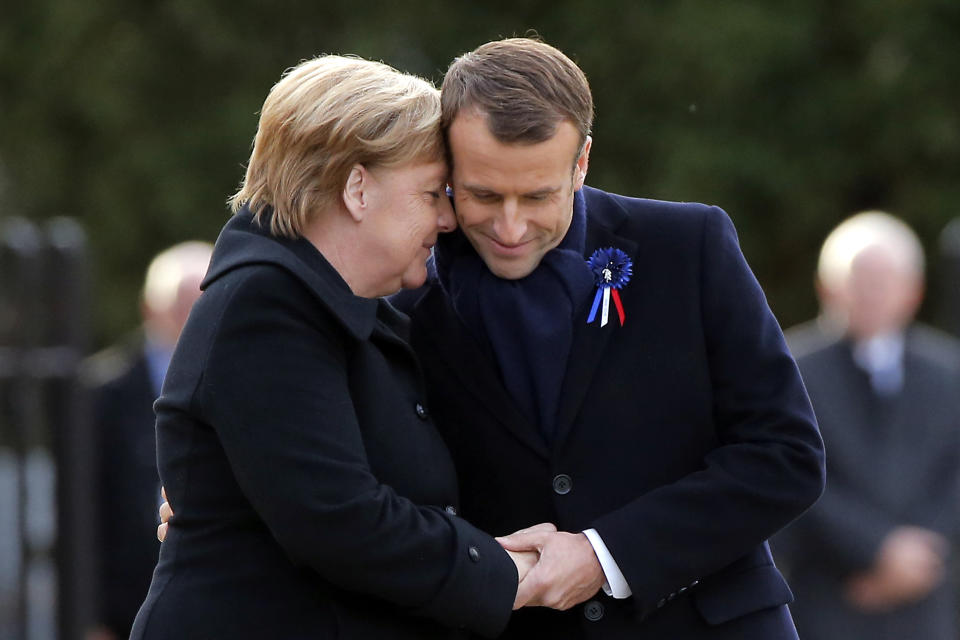 French President Emmanuel Macron, right, holds the hands of German Chancellor Angela Merkel during a ceremony in Compiegne, north of Paris, Saturday, Nov. 10, 2018. The leaders of France and Germany have held an intimate commemoration at the site north of Paris where the vanquished Germans and victorious but exhausted Allies put an end to World War 1.(AP Photo/Michel Euler)