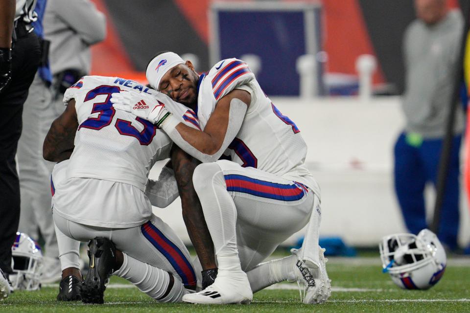 Buffalo Bills' Siran Neal (33) and Nyheim Hines react after teammate Damar Hamlin was injured during the first half of an NFL football game against the Cincinnati Bengals Monday in Cincinnati.