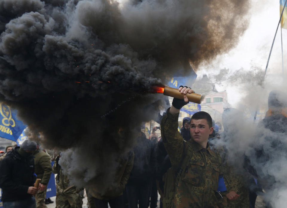 <p>Members of the nationalist movement Svoboda (Freedom) are shrouded in smoke from flares as they march marking the 74th anniversary of the Ukrainian Insurgent Army in Kiev, Ukraine, Oct. 14, 2016. Ukraine celebrates the Day of Defenders of Ukraine. (Photo: Sergei Chuzavkov/AP)</p>