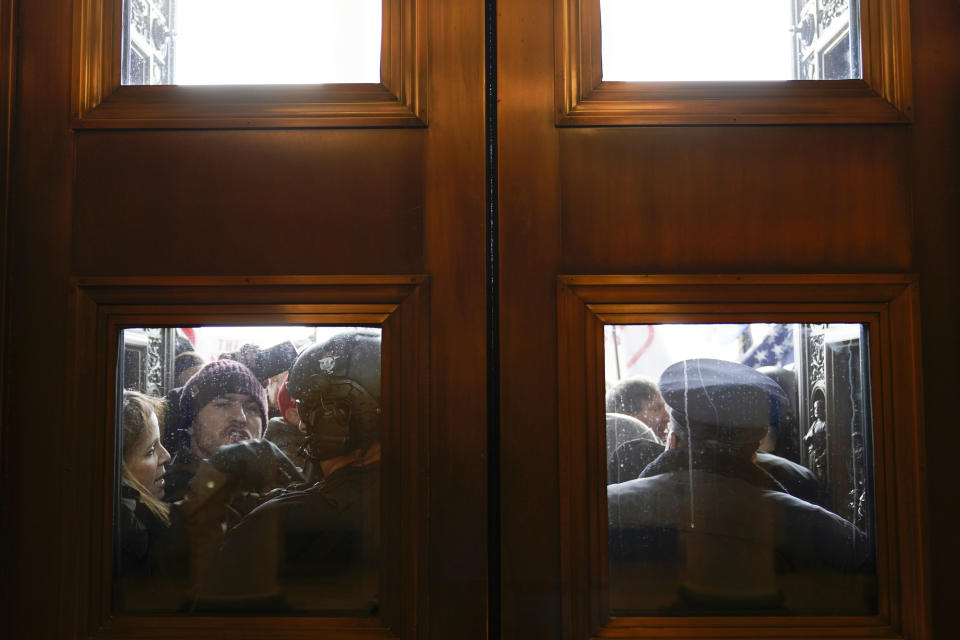 U.S. Capitol Police try to hold back rioters outside the east doors to the House side of the U.S. Capitol, Jan 6, 2021. (AP Photo/Andrew Harnik)