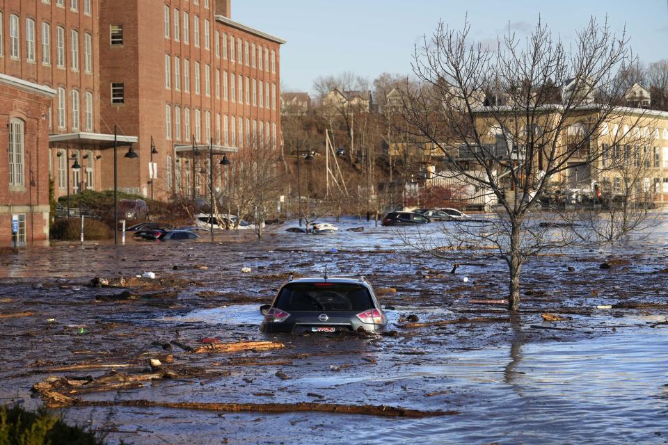 Cars are flooded in a parking lot at the Hathaway Creative Center alongside the Kennebec River, Tuesday, Dec. 19, 2023, in Waterville, Maine. A severe storm on Monday flooded rivers and knocked out power to hundreds of thousands. (AP Photo/Robert F. Bukaty)