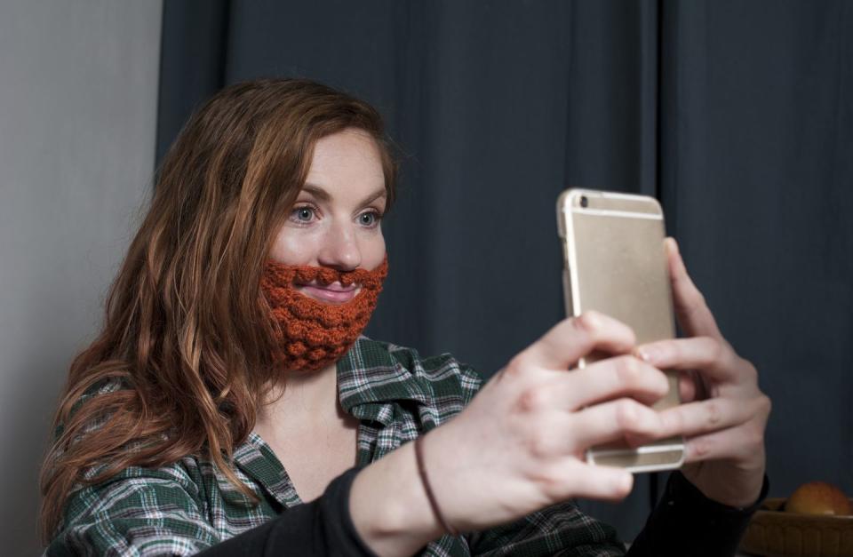 woman wearing red crochet beard taking a selfie for saint patrick's day