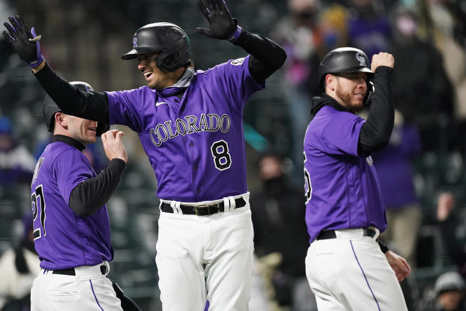 Colorado Rockies' Josh Fuentes, center, celebrates his three-run home run with Trevor Story, left, and C.J. Cron off New York Mets relief pitcher Jacob Barnes during the fifth inning of the second game of a baseball doubleheader Saturday, April 17, 2021, in Denver. (AP Photo/David Zalubowski)