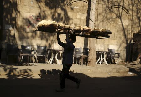 A bakery worker carries freshly baked bread on his head to deliver it to shops in Cairo, Egypt, February 14, 2016. REUTERS/Asmaa Waguih