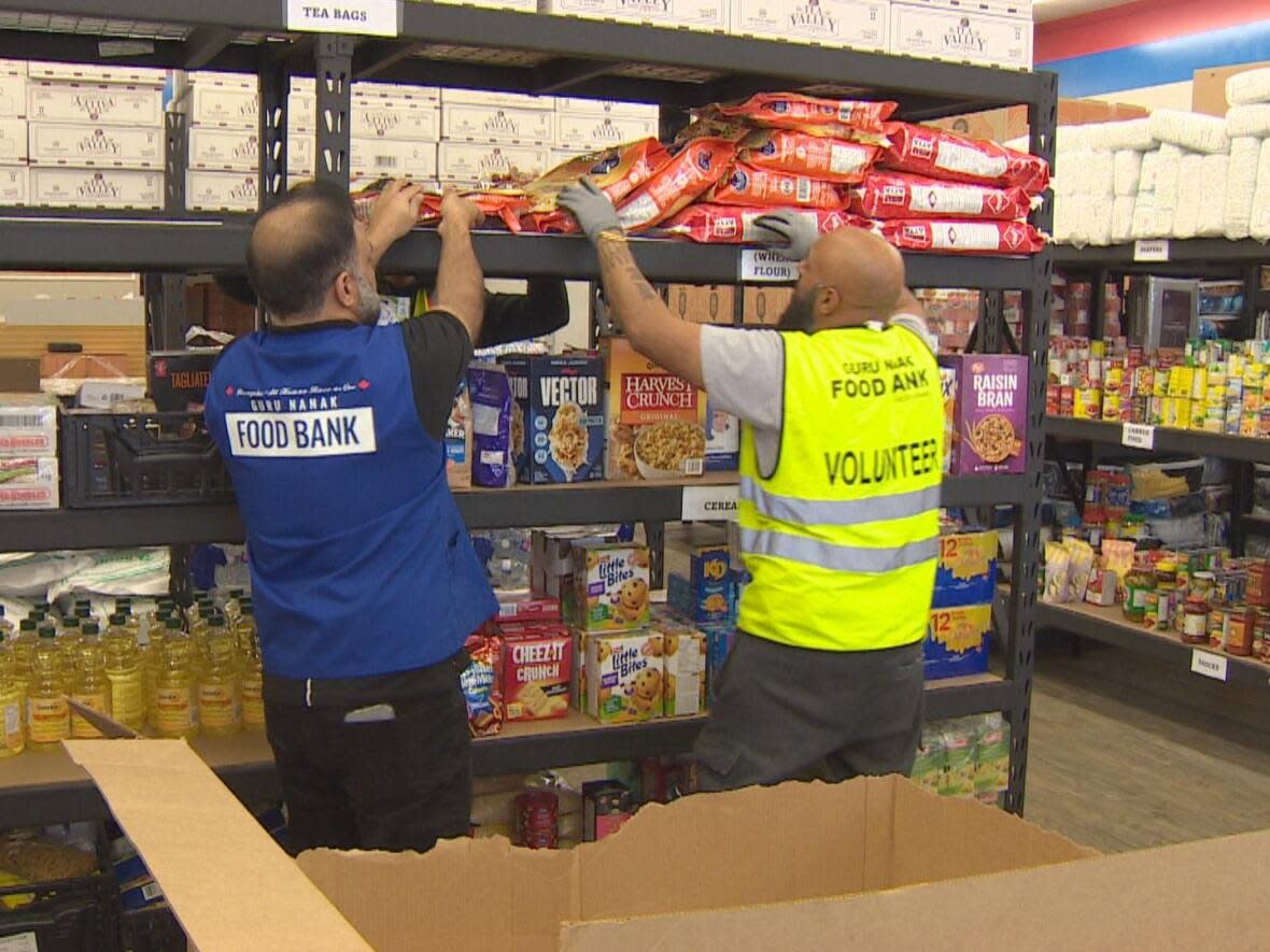 The Guru Nanak Food Bank, which has locations across the Lower Mainland, says they've set up a helpline to help newcomers acclimatize to B.C. Secretary Neeraj Walia, left, says he's heard of many newcomers facing alienation and homesickness. (CBC - image credit)