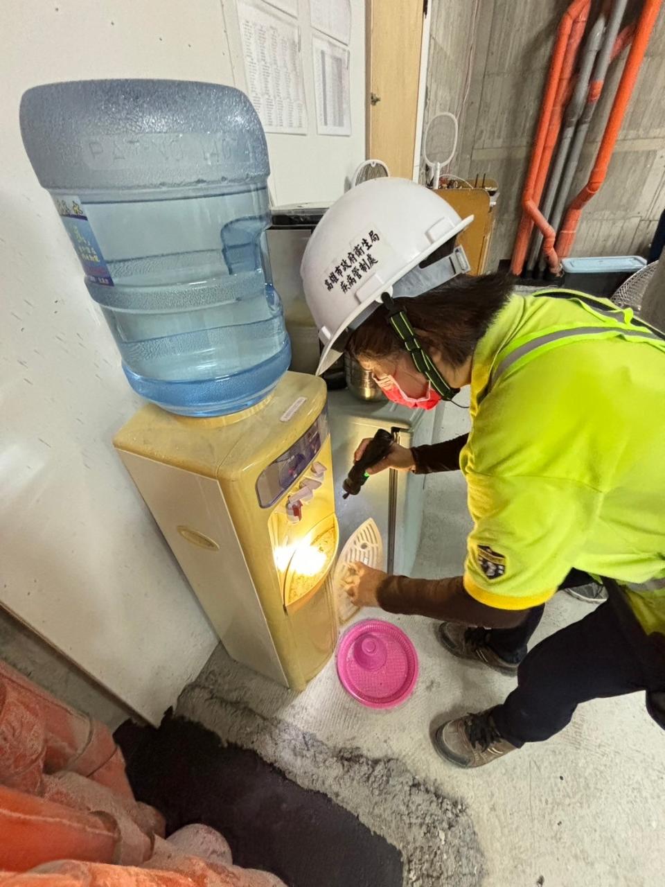 防疫人員針對飲水機底盤檢查孳生源。（圖：高市衛生局提供）