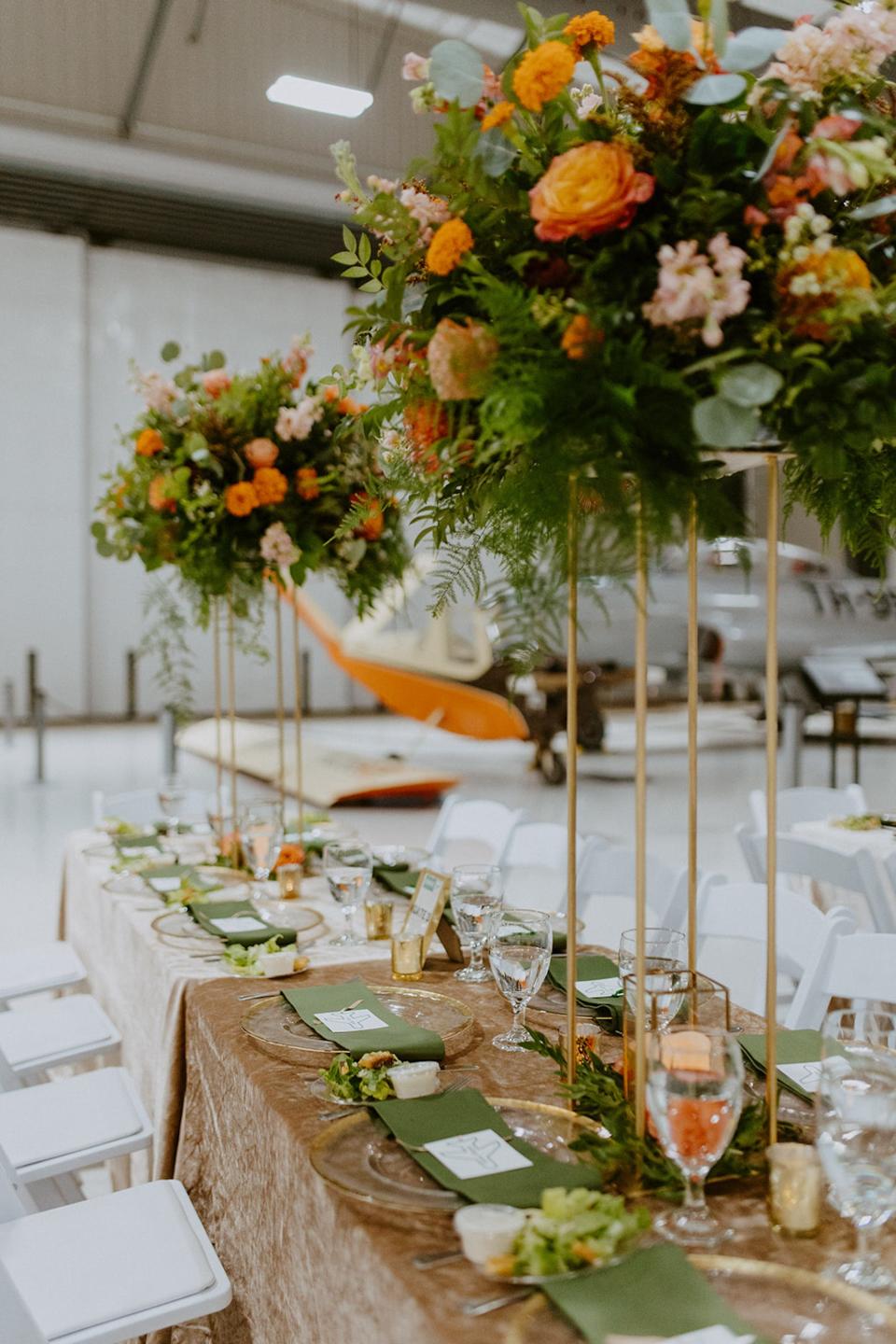 Wedding tables with tall flower arrangements.