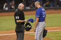 MLB umpire Mike Estabrook (83) inspect the hat of Toronto Blue Jays relief pitcher Tim Mayza (58) during the eighth inning of a baseball game against the Miami Marlins, Wednesday, June 23, 2021, in Miami. (AP Photo/Marta Lavandier)