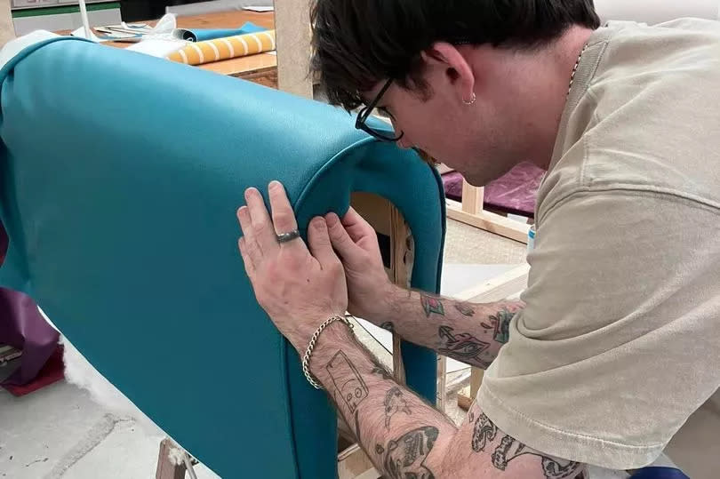 An apprentice working on the upholstery