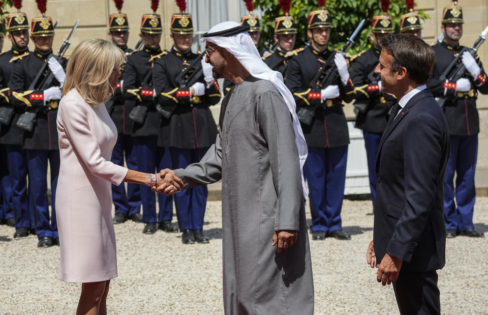 Brigitte Macron, left, and France's President Emmanuel Macron, right, welcome United Arab Emirates' President Sheikh Mohammed Bin Zayed at the Elysee Palace in Paris, Monday, July 18, 2022. United Arab Emirates' President Sheikh Mohammed Bin Zayed is for a two-days visit in France. (AP Photo/Michel Euler)