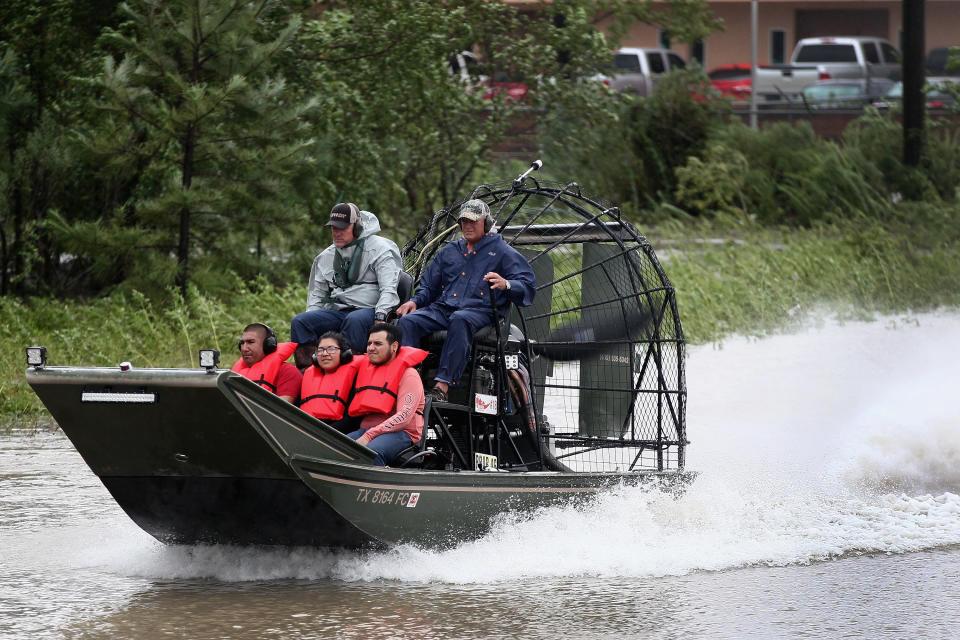 Rescue workers and volunteers help residents make their way out of a flooded Houston neighborhood following Hurricane Harvey on Aug. 29. (Photo: Scott Olson/Getty Images)