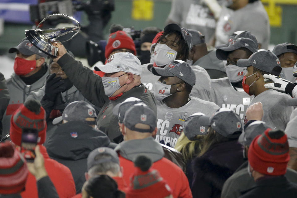 Tampa Bay Buccaneers head coach Bruce Arians holds the championship trophy after winning the NFC championship NFL football game against the Green Bay Packers in Green Bay, Wis., Sunday, Jan. 24, 2021. The Buccaneers defeated the Packers 31-26 to advance to the Super Bowl. (AP Photo/Mike Roemer)