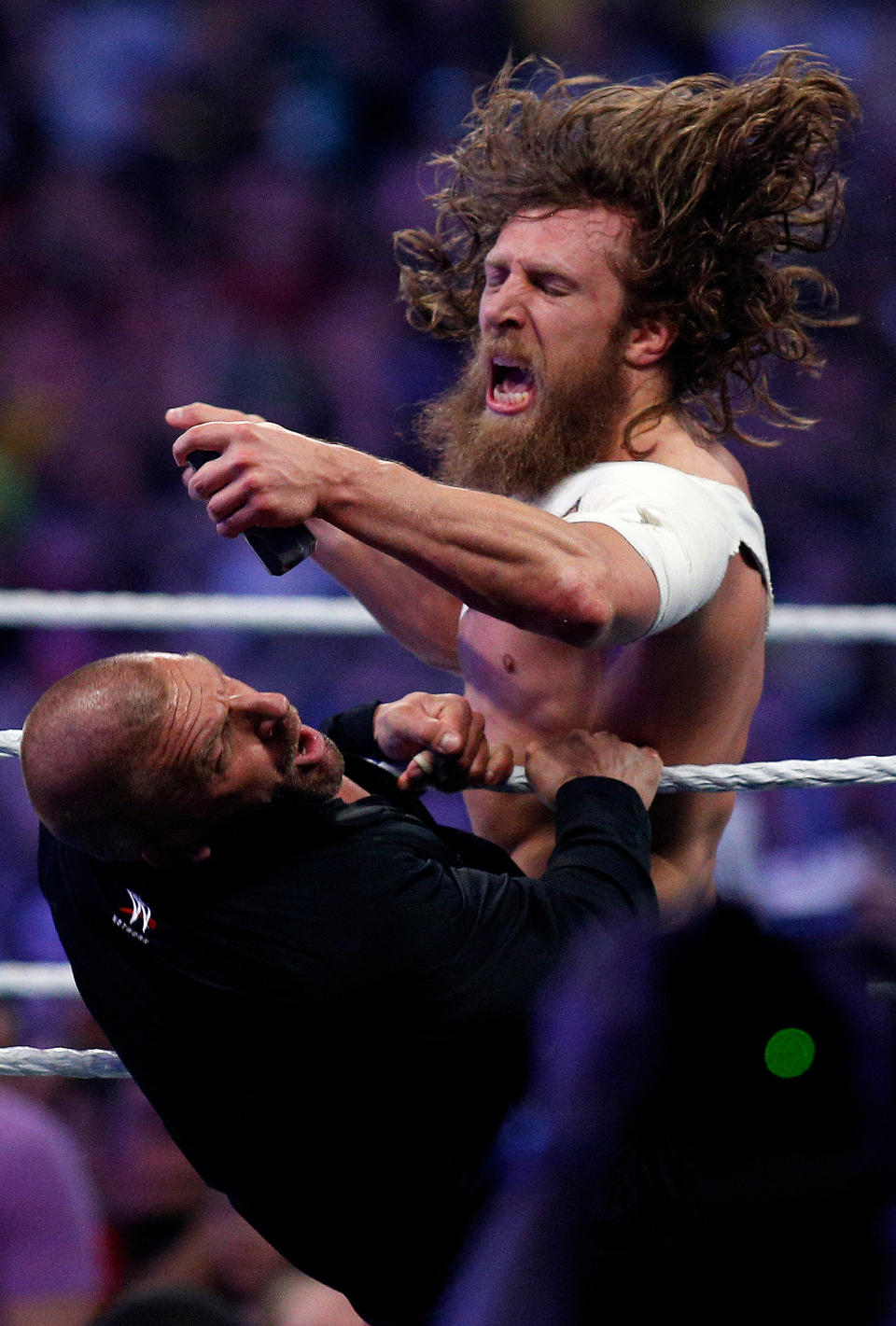 Daniel Bryan, top, hits Triple H with a sledgehammer during Wrestlemania XXX at the Mercedes-Benz Super Dome in New Orleans on Sunday, April 6, 2014. (Jonathan Bachman/AP Images for WWE)