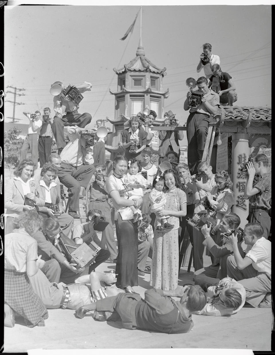 A mob of photographers descended upon China City, Los Angeles, when they heard that a prize contest is under way for the best amateur snaps of its people and its colorful nooks and corners. Pictured is a mob of candid camera fans shooting Mrs. Dorothy Siu (CQ) and Mrs. Chung Dat Loo as they hold little Gwendolyn Loo and Evelyn Loo on Oct. 1939<span class="copyright">Bettmann Archive/Getty Images</span>