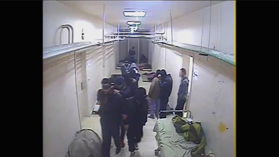 Another still from the security camera footage shows men in a corridor. CNN has blurred a face in this image, provided by CIJA, to conceal the person's identity. - Courtesy Commission for International Justice and Accountability