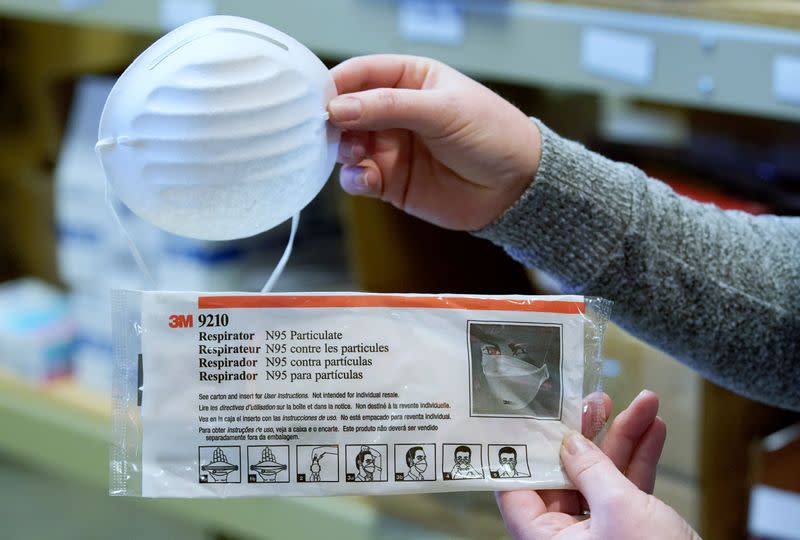 A standard dust & particle mask, and an N95 medical respirator mask (bottom), that are part of personal protection and survival equipment kits ordered by customers preparing against novel coronavirus, are seen at Nitro-Pak in Midway