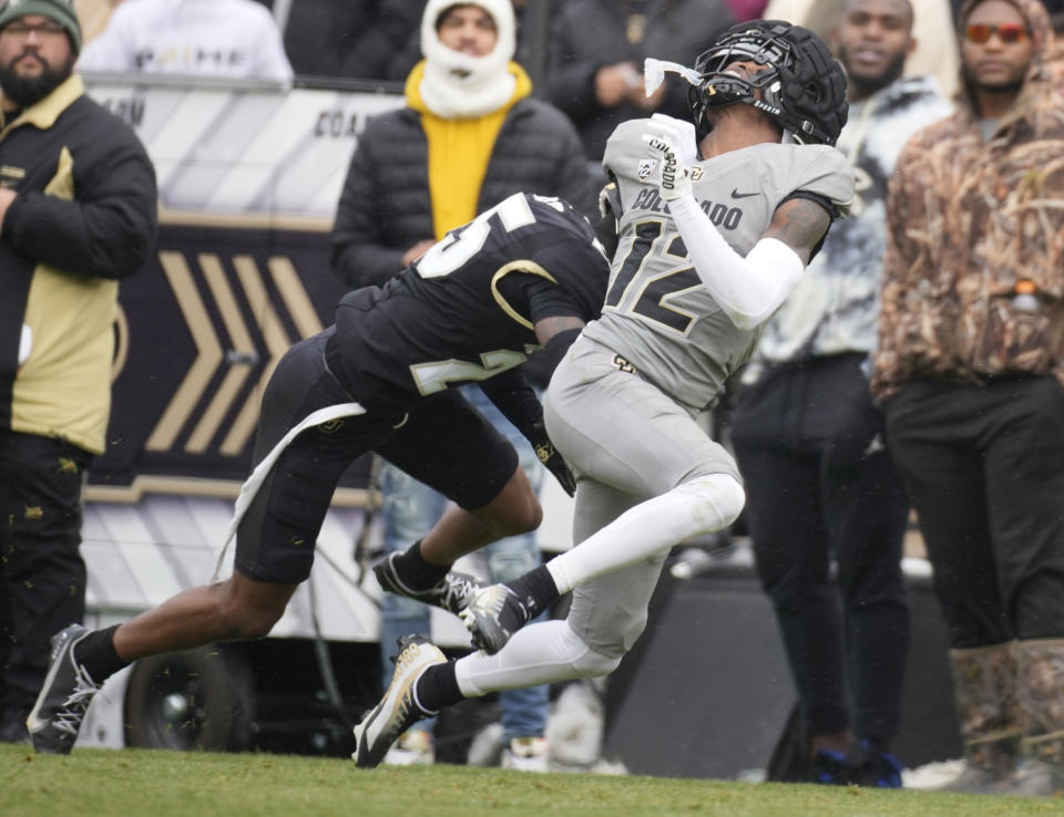 Colorado inside linebacker Marvin Ham II, left, runs into wide receiver Travis Hunter in the first half of the team's spring practice NCAA college football game Saturday, April 22, 2023, in Boulder, Colo. (AP Photo/David Zalubowski)