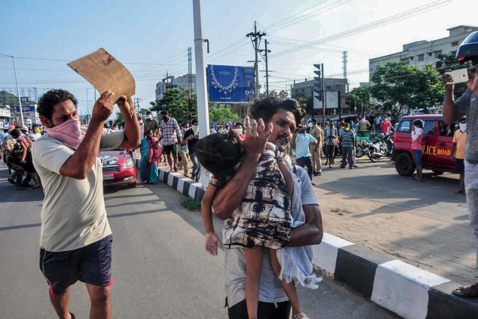 A man carries a fainted young girl (R) to evacuate her following a gas leak incident at an LG Polymers plant in Visakhapatnam on May 7, 2020. - Eleven people were killed and hundreds hospitalised after a pre-dawn gas leak at a chemical plant in eastern India on May 7 that left unconscious victims lying in the streets, authorities said. Fears that the death toll from the incident on the outskirts of the Visakhapatnam, an industrial port city in Andhra Pradesh state, might rise significantly were not borne out however. (Photo by STR / AFP) (Photo by STR/AFP via Getty Images)