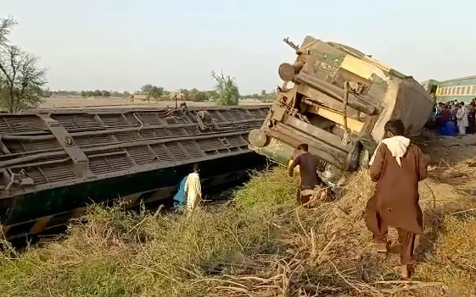 Several green Pakistan railway carriages on their side - AP Video