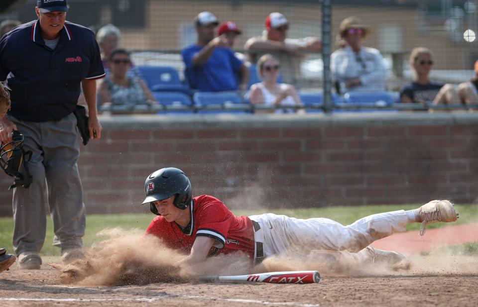 New Boston Huron's Kyle Kantola slides into home with the go-ahead run in the top of the 10th inning against Airport in the finals of the División 2 District at Airport Saturday. Huron won 4-1 in 10 innings.