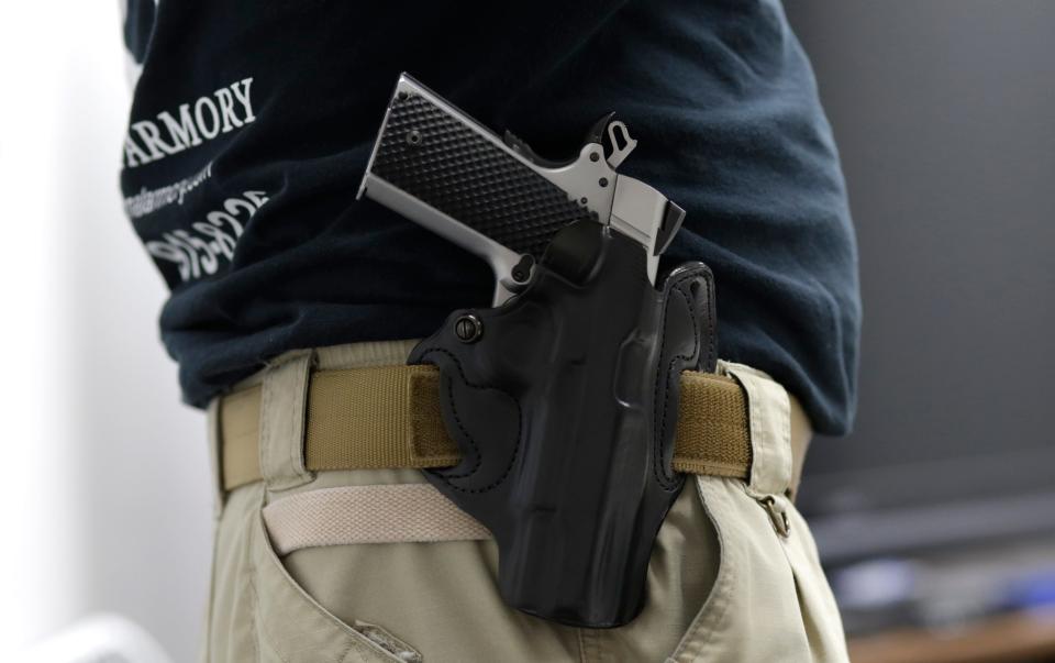 Mike Weinstein, director of training and security at the National Armory gun store and gun range, has a Ruger 1911hand gun in a holster as he teaches a Concealed Weapons Permit class, Tuesday, Jan. 5, 2016, in Pompano Beach, Fla. President Barack Obama unveiled his plan Tuesday to tighten control and enforcement of firearms in the U.S. (AP Photo/Lynne Sladky)