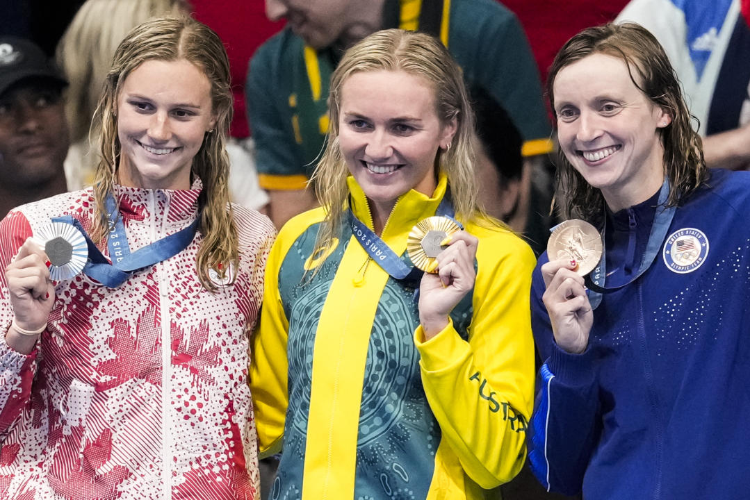 Gold medalist, Ariarne Titmus, of Australia, stands with silver medalist, Summer McIntosh, of Canada, left, and bronze medalist Katie Ledecky, of the United States, right, after the women's 400-meter freestyle final at the 2024 Summer Olympics, Saturday, July 27, 2024, in Nanterre, France. (AP Photo/Martin Meissner)