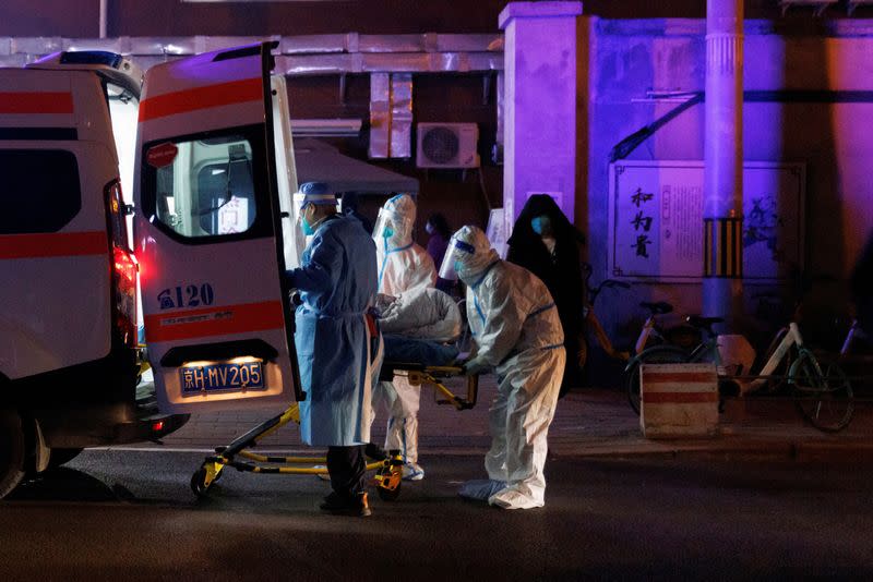 FILE PHOTO: Medics wear personal protection gear as they deliver a patient to a fever clinic of a hospital as coronavirus disease (COVID-19) outbreaks continue in Beijing