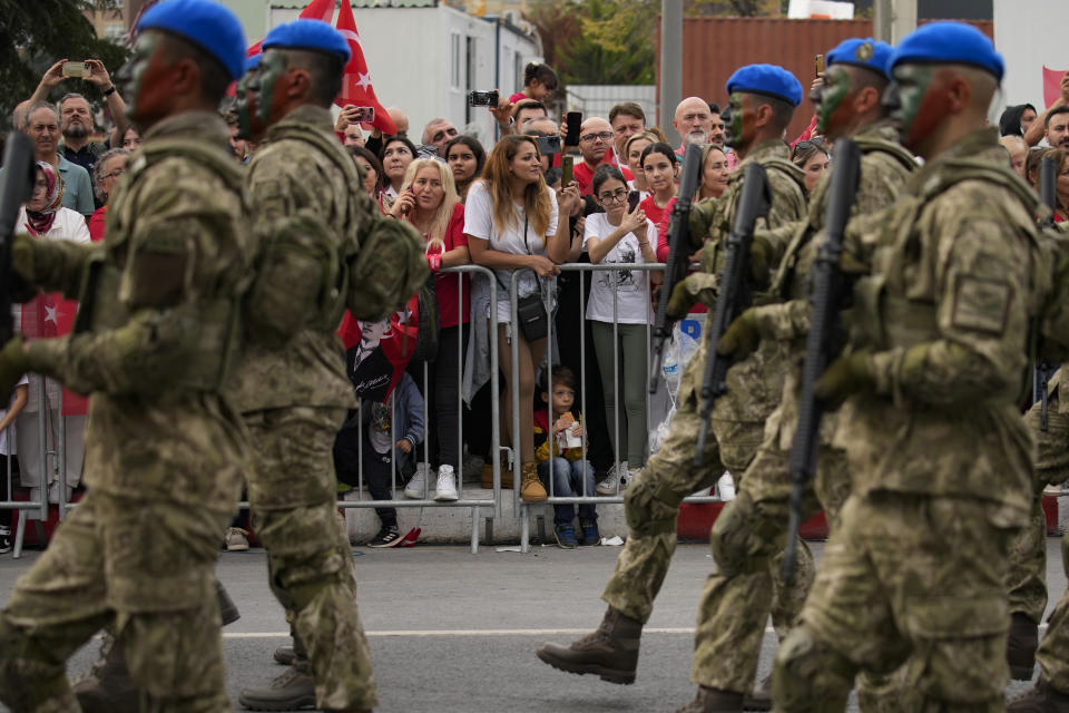 People watch Turkey's army soldiers in a parade as part of celebrations marking the 100th anniversary of the creation of the modern, secular Turkish Republic, in Istanbul, Turkey, Sunday, Oct. 29, 2023. (AP Photo/Emrah Gurel)