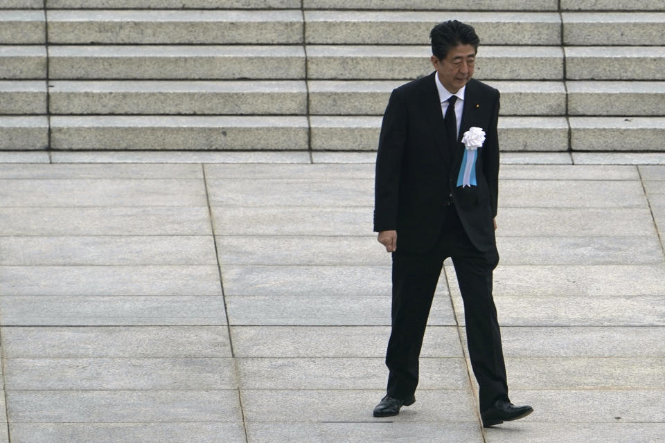 FILE - In this Aug. 6, 2020, file photo, Japanese Prime Minister Shinzo Abe walks off after delivering a speech during a ceremony to mark the 75th anniversary of the bombing at the Hiroshima Peace Memorial Park, in Hiroshima, western Japan. Abe went to a hospital Monday, Aug. 17, for what Japanese media reported was a regular checkup, although the visit regenerated ongoing worries about his health. (AP Photo/Eugene Hoshiko, File)