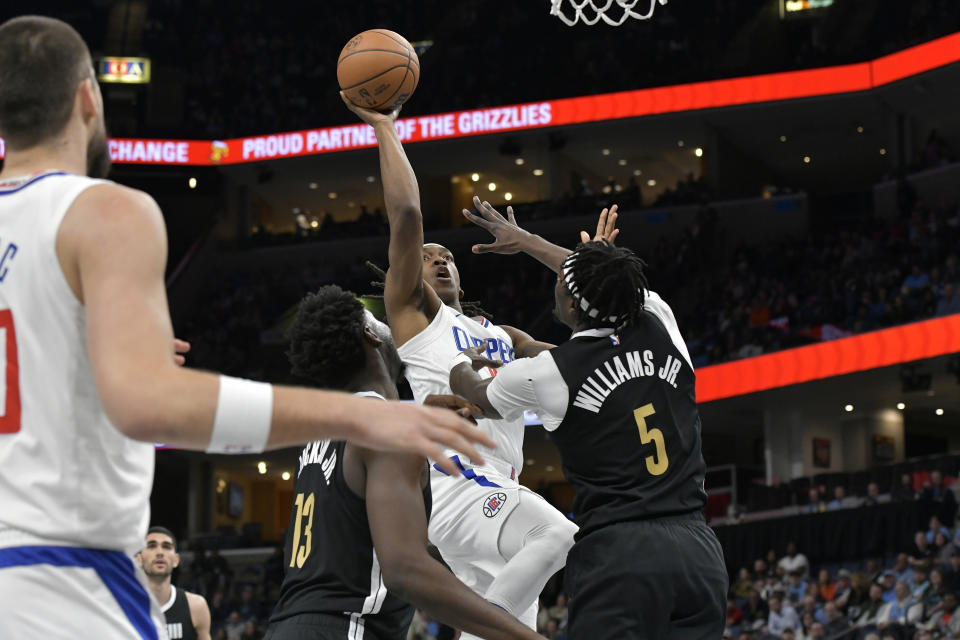 Los Angeles Clippers guard Terance Mann shoots against Memphis Grizzlies forward Jaren Jackson Jr. (13) and guard Vince Williams Jr. (5) during the first half of an NBA basketball game Friday, Feb. 23, 2024, in Memphis, Tenn. (AP Photo/Brandon Dill)