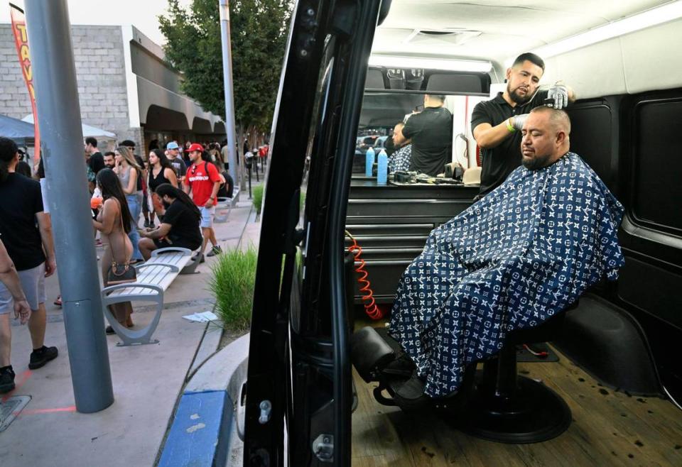 A mobile barber works out of his van along Fulton Street during ArtHop, Thursday, Aug. 3, 2023.