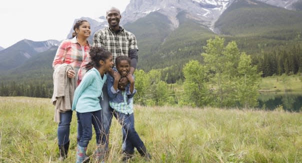 Family standing in grassy field