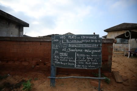 Sign advertising food and tourism services is seen at a closed down hotel near the monument at the 'Point of No Return' at the historic slave port of Ouidah, Benin