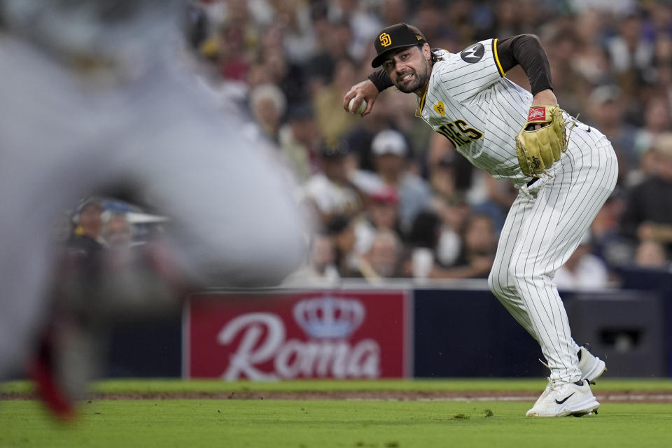 San Diego Padres starting pitcher Matt Waldron holds his throw to first as Washington Nationals' Joey Meneses, left, makes it to first base for an RBI single during the fifth inning of a baseball game Monday, June 24, 2024, in San Diego. (AP Photo/Gregory Bull)