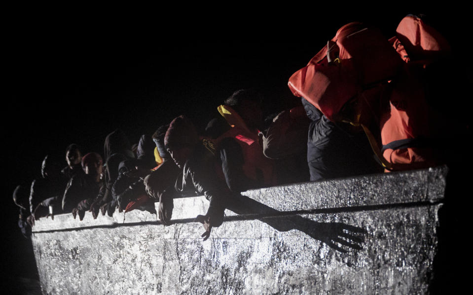 Dozens of migrants sit in a wooden boat off the waters of Tunisia early Wednesday, May 25, 2022. Some 110 people were rescued by the non-governmental organization Open Arms during a mission in the Mediterranean Sea after their boat capsized. (AP Photo/Valeria Ferraro)