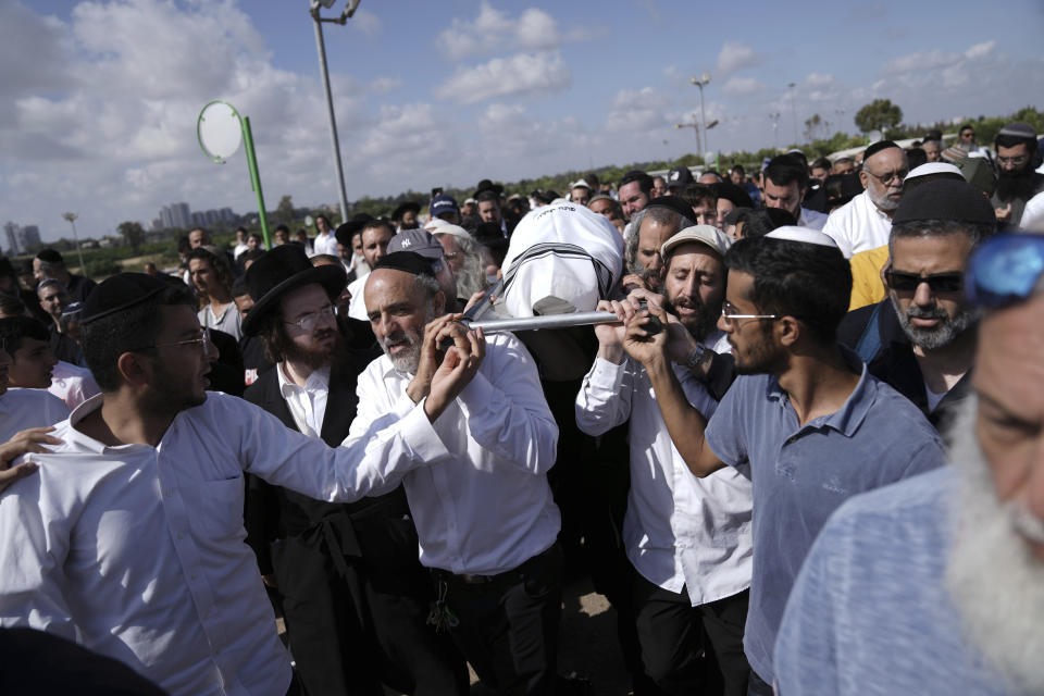 Mourners carry Yonatan Havakuk to his burial in Petah Tikva, Israel, the day after he was killed with two others in a stabbing attack in Elad, Friday, May 6, 2022. Israeli security forces waged a massive manhunt Friday for two Palestinians suspected of carrying out the stabbing attack on Thursday near Tel Aviv that left three Israelis dead.(AP Photo/Ariel Schalit)